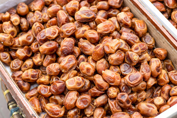 A pile of fresh organic ripe date fruit close up on a wooden basket