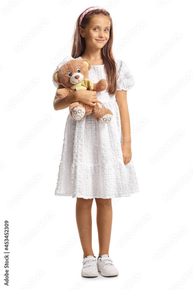 Wall mural Full length portrait of a girl in a white dress holding a teddy bear