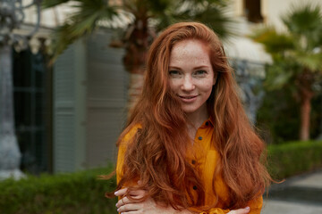 Young beautiful woman with long red hair outdoors portrait.