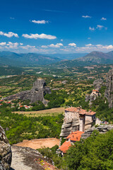 Fototapeta na wymiar ギリシャ　メテオラの断崖絶壁の岩山の上に建つルサヌ修道院と聖ニコラオス・アナパフサス修道院と後ろに広がる大自然