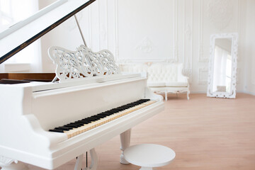 White grand piano standing in elegant classical interior