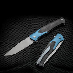 Folding pocket knife with a clip on a dark back. Handle with carbon and color inserts.