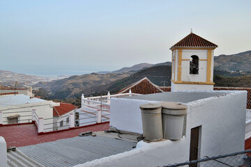 Lujar church tower and houses with the sea in the background
