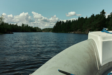 Front view of motor part of rubber boat cruising down lake, pictured against deep blue water...