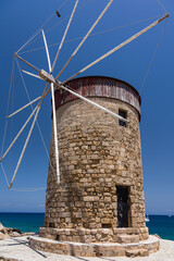 Fototapeta na wymiar ギリシャ　ロードス島のロードスのマンドラキ港に建つ風車
