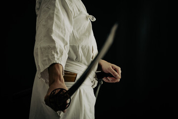 黒い背景と日本刀を構える人物