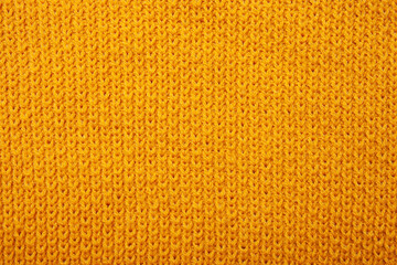Knitted sweater texture. Abstract knitted fabric as background. Yellow wooled pattern, copy space text, top view, macro view