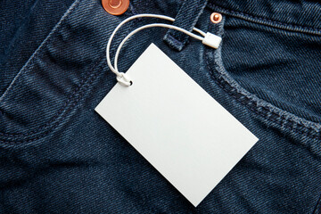 Cardboard tag on jeans texture with place for text. Empty label blank on cloth. Sale, discount and...