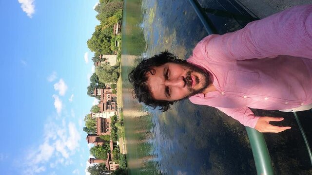 happy tourist visiting Turin (Torino), piedmont, Italy. Happy man take selfi photo with Borgo Medieval village and fortress of Turin and river Po. Fisheye lens 