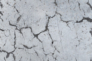 Cracks in old cement street road. Textured grungy pattern backdrop