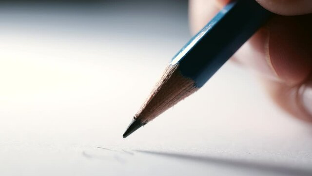 Close-up of pencil writing on white paper in slow motion