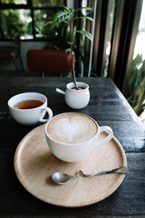 Fototapeta na wymiar Foamed milk latte heart, Cup of hot coffee on the table in a cafe
