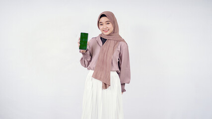Young woman in hijab showing mobile phone screen isolated on white background