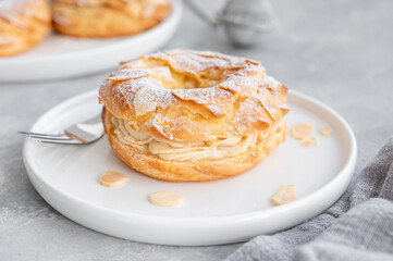 French traditional cake Paris Brest with praline cream, powdered sugar and almond petals on top on...