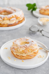 French traditional cake Paris Brest with praline cream, powdered sugar and almond petals on top on...