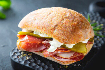 Ciabatta sandwich with thin slices of smoked pork and pickles