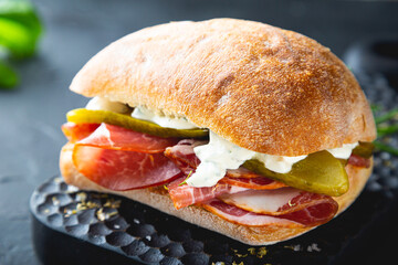Ciabatta sandwich with thin slices of smoked pork and pickles