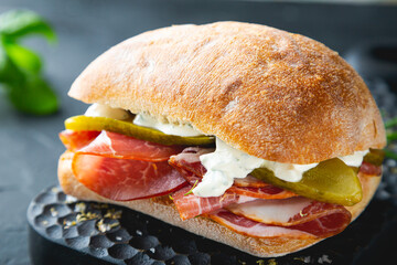Ciabatta sandwich with thin slices of smoked pork and pickles