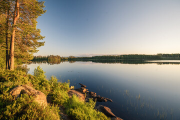 Naklejka na ściany i meble wunderschöner sonnenuntergang an einem see mitten in schwedens natur.