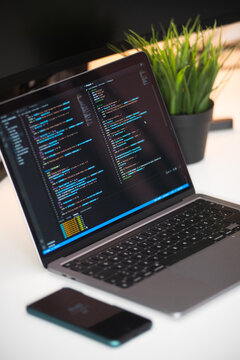 Minimalistischer Arbeitsplatz mit Laptop Handy gr&uuml;ner pflanze und einem Notizbuch.