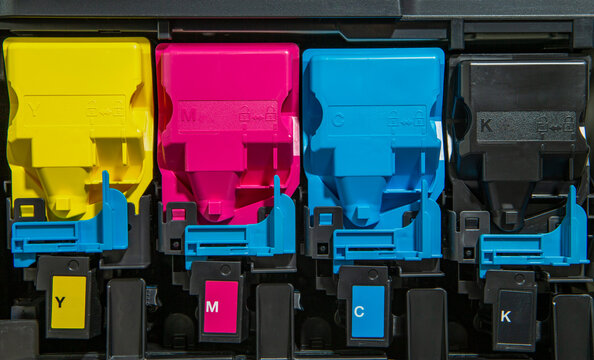 The photo shows an open printer with a view of the colored toner cartridges