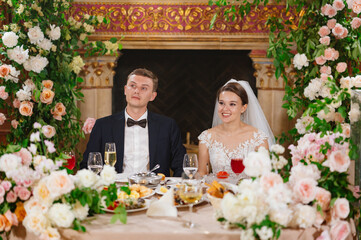 happy bride and groom at the table in the restaurant hall. festive banquet. 
