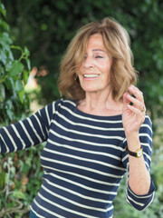 Elder Italian woman in striped clothes enjoying the vibes in a park