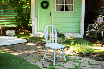 White wooden chair. Cozy terrace in garden with wooden chair. Decor in summer patio for relax. Autumn front porch home. Exterior wooden porch home with garden furniture. Interior summer patio. 
