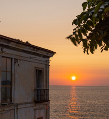 Obraz premium Colorful Sunset with abandoned building on the left and orange sky
