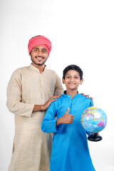 Indian child holding world globe in hand and his father giving some information.