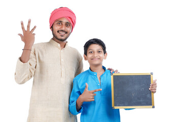 Education concept : Indian farmer with his child showing blank chalkboard on white background.