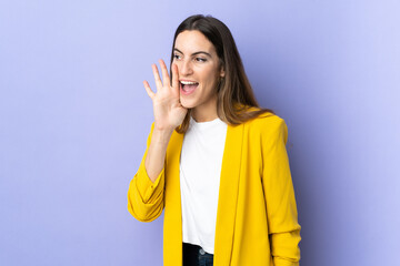 Young caucasian woman over isolated background shouting with mouth wide open to the side