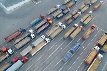Cargo transportation. Many trucks are waiting in line for unloading in the port harbor, top view...