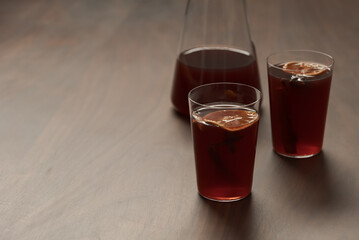 Mulled wine in tumbler glasses on walnut table with copy space