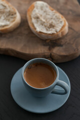 Espresso in blue cup with sandwiches with cream cheese on background