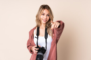 Young photographer girl over isolated background points finger at you with a confident expression