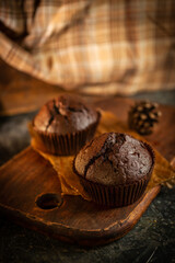 Chocolate muffins on the rustoic wooden background