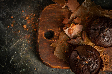 Chocolate muffins on the rustoic wooden background