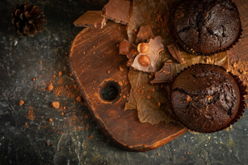 Chocolate muffins on the rustoic wooden background