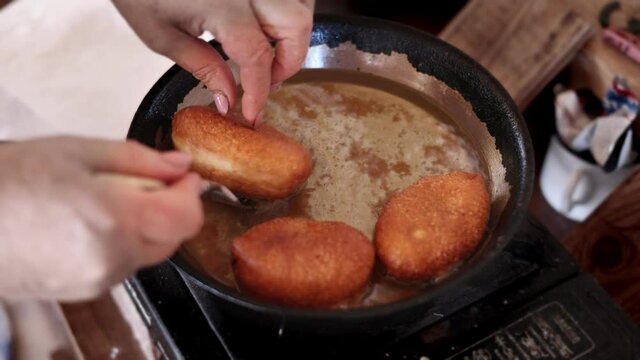 pies are cooked in a pan in oil