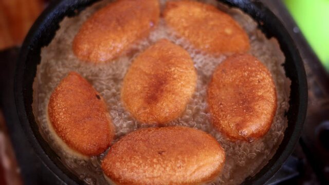 pies are cooked in a pan in oil