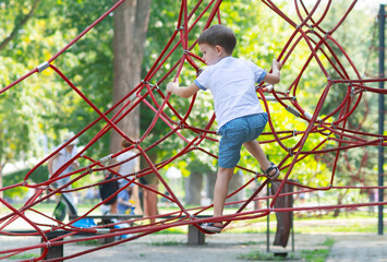 Boy climbing the ropes in the playground