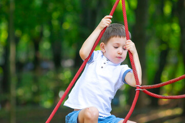 Boy practicing rope climbing in a city park