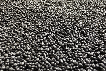 Polypropylene granule close-up. Plastic black granulated crumb. Background abstract texture. Black...