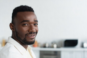 cheerful african american man smiling and looking at camera