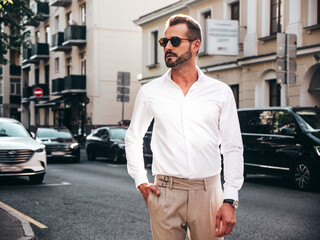 Portrait of handsome confident stylish hipster lambersexual model.Modern man dressed in white shirt...
