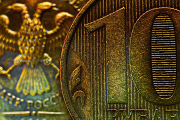 A fragment of a Russian coin in 10 ten rubles close up. Dark impressive illustration. Economy, finance and banks of Russia. Scratched coins from circulation. Macro
