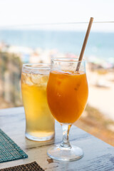 Glass of orange juice on beach, Praia do Garrão, Algarve