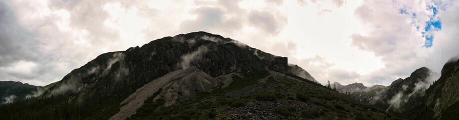 Panorama von den Alpen bei Gramais in &Ouml;sterreich mit Wolken, hohen Berge und Steinlawinen (Muren)