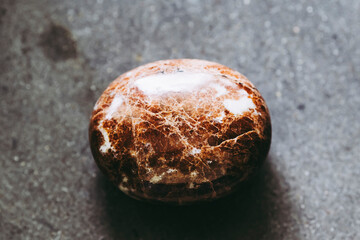 Galet pierre roul&eacute;e polie cornaline sur un fond noir - Min&eacute;ral naturel